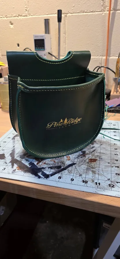 Custom Pine Ridge ammo pouch in green leather with gold stamp