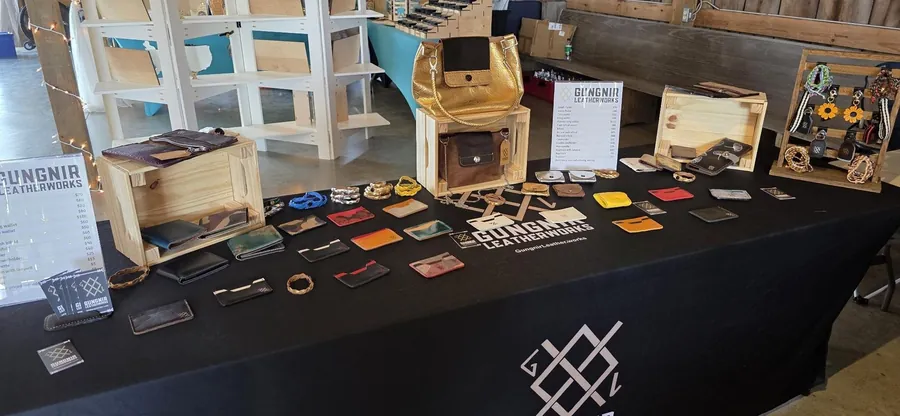 The Gungnir Leatherworks booth, table covered in handmade wallets and cardholders