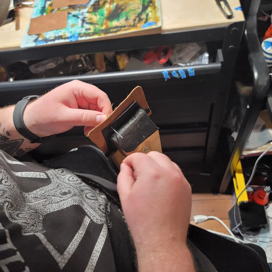 Stitching a piece by hand at the Gungnir workbench